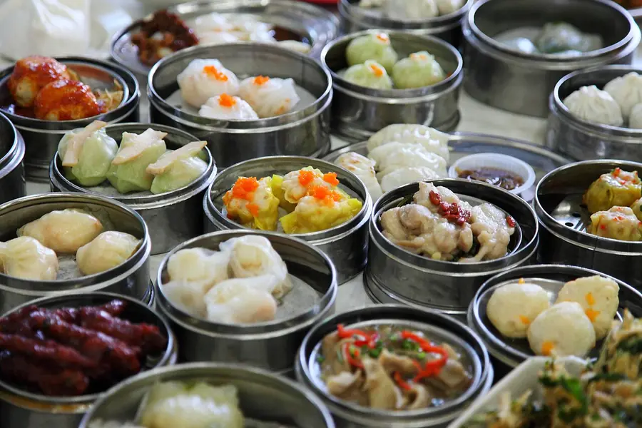 Steamer baskets and small plates of dim sum crowded on a table