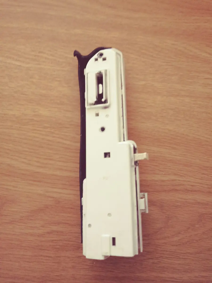 Old door latch mechanism lying on a wooden surface