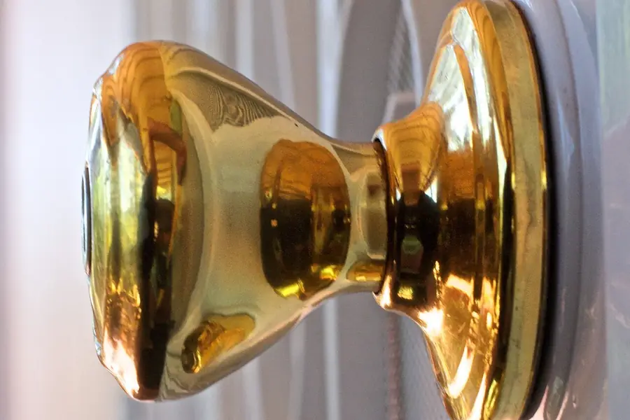 Round brass doorknob on a painted front door