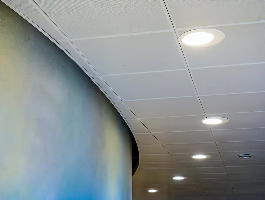 Row of recessed downlights in a curved ceiling