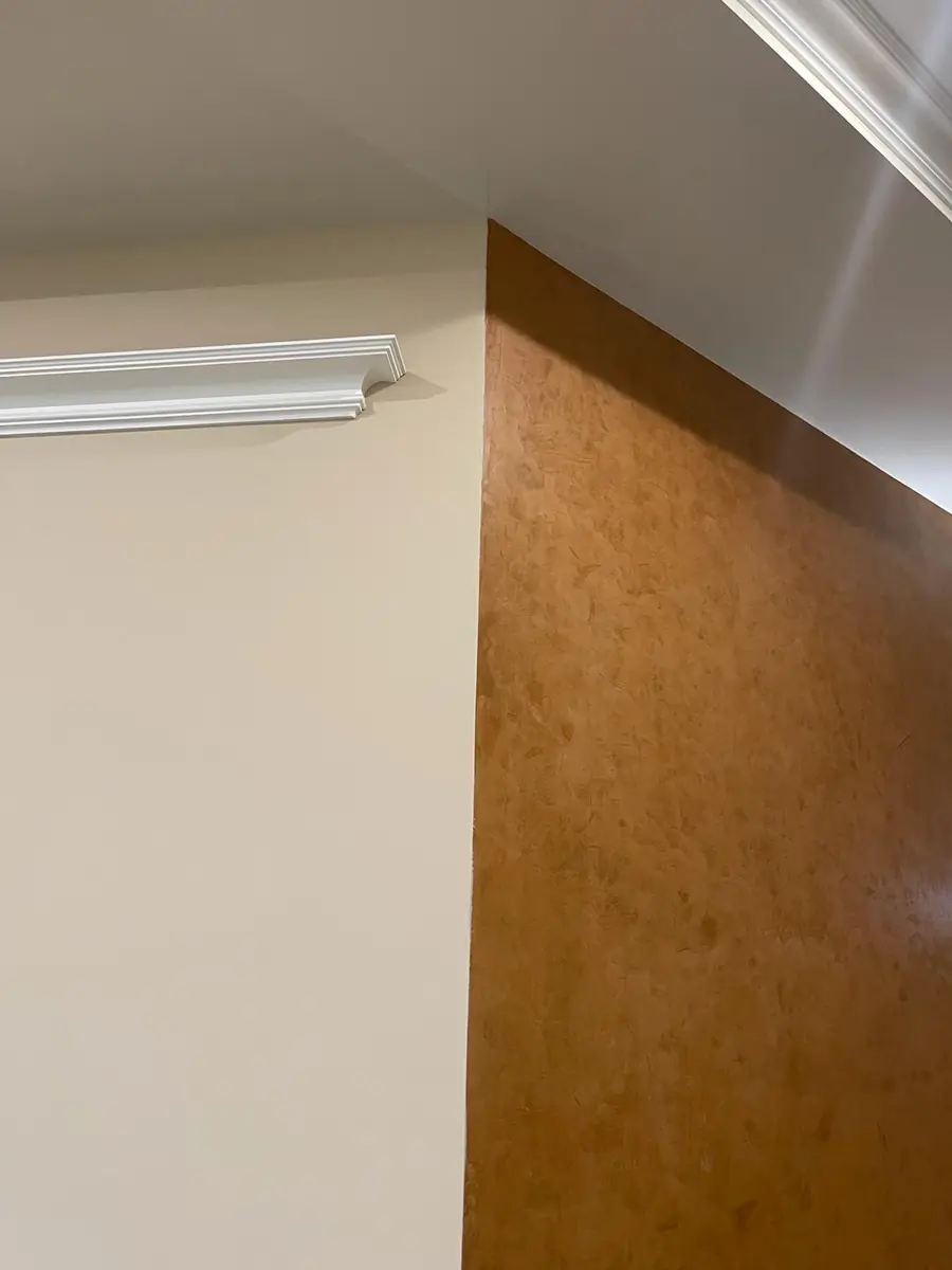 Interior wall corner where white drywall meets a brown gypsum board panel