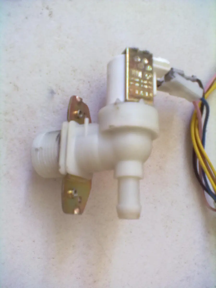 White plastic washing machine water inlet valve with wire connectors attached