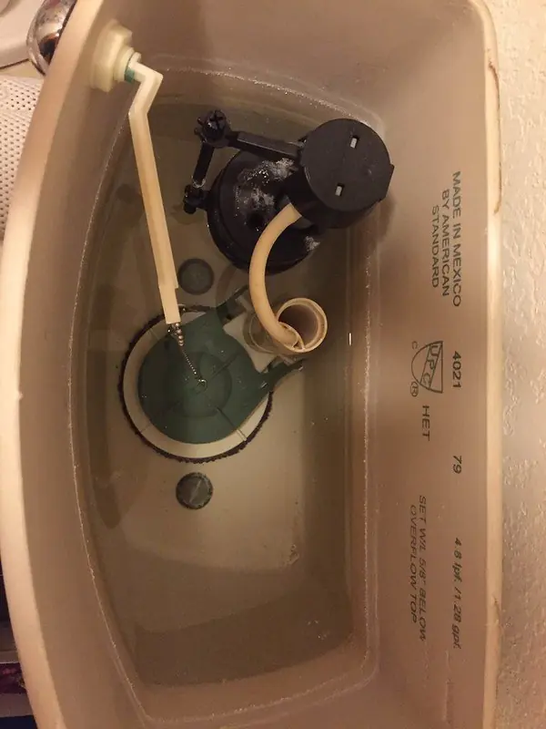Inside a toilet tank showing the fill valve, float and flush valve