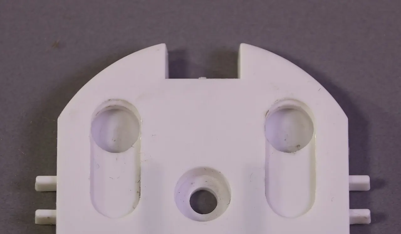 White plastic child safety insert that covers wall outlet holes