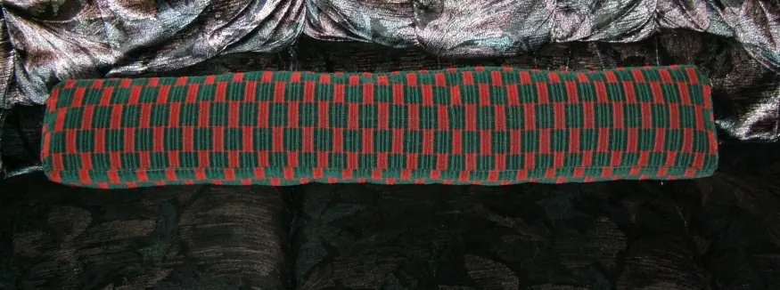 Long knitted fabric draft stopper laid flat, the kind set along the bottom of a door