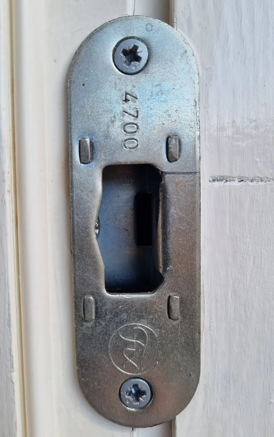 Metal strike plate that the door latch catches in