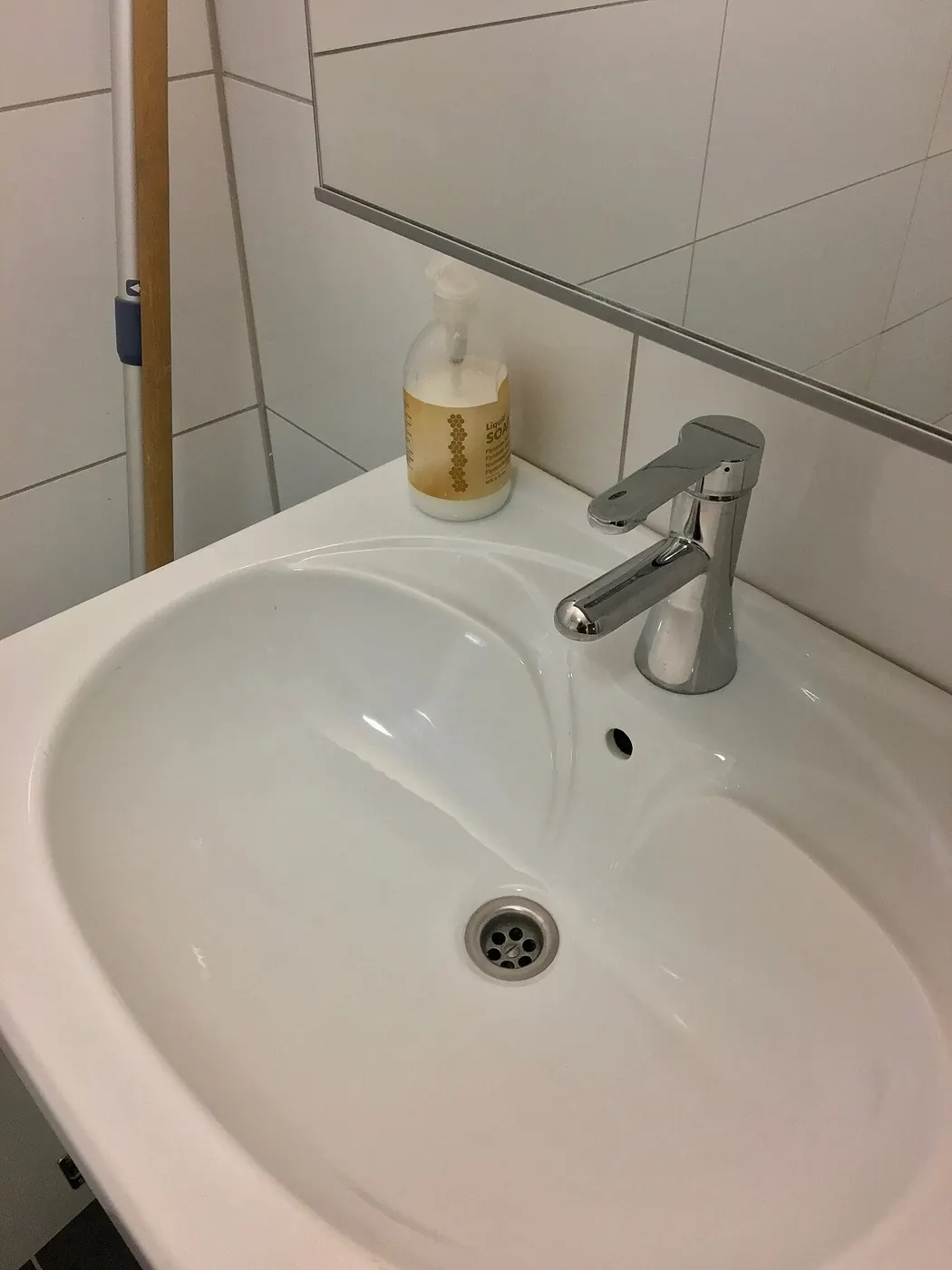 Small porcelain hand basin with a faucet in a bathroom