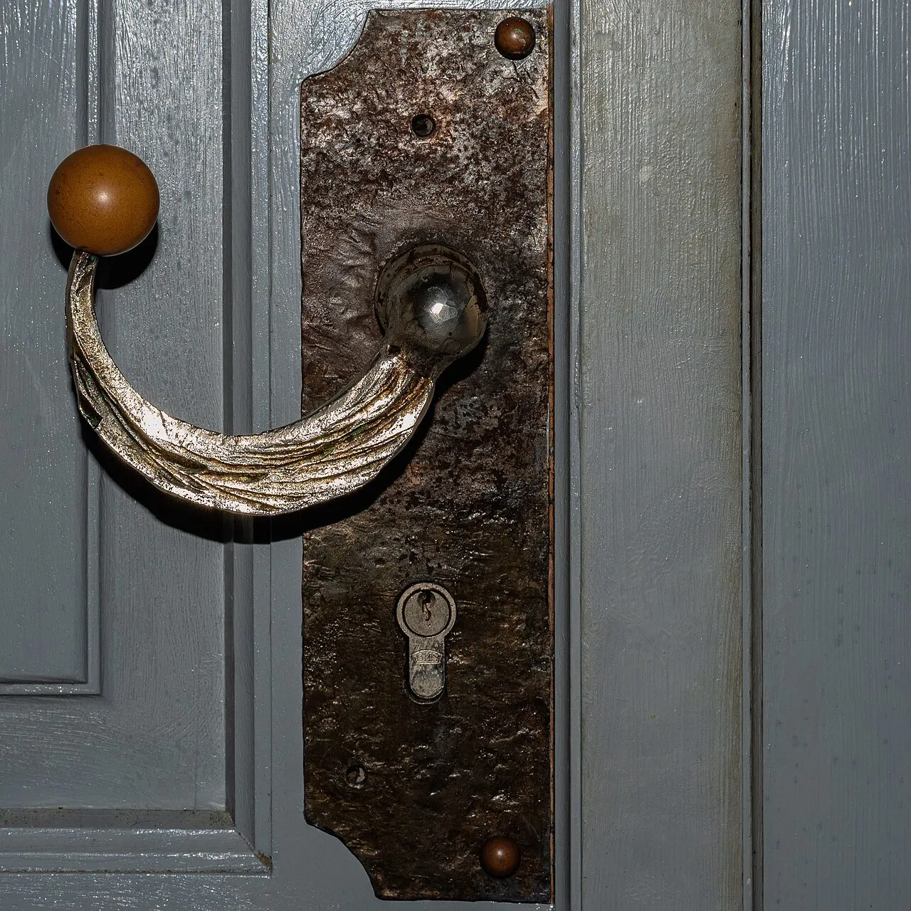 Old lever door handle on a wooden door