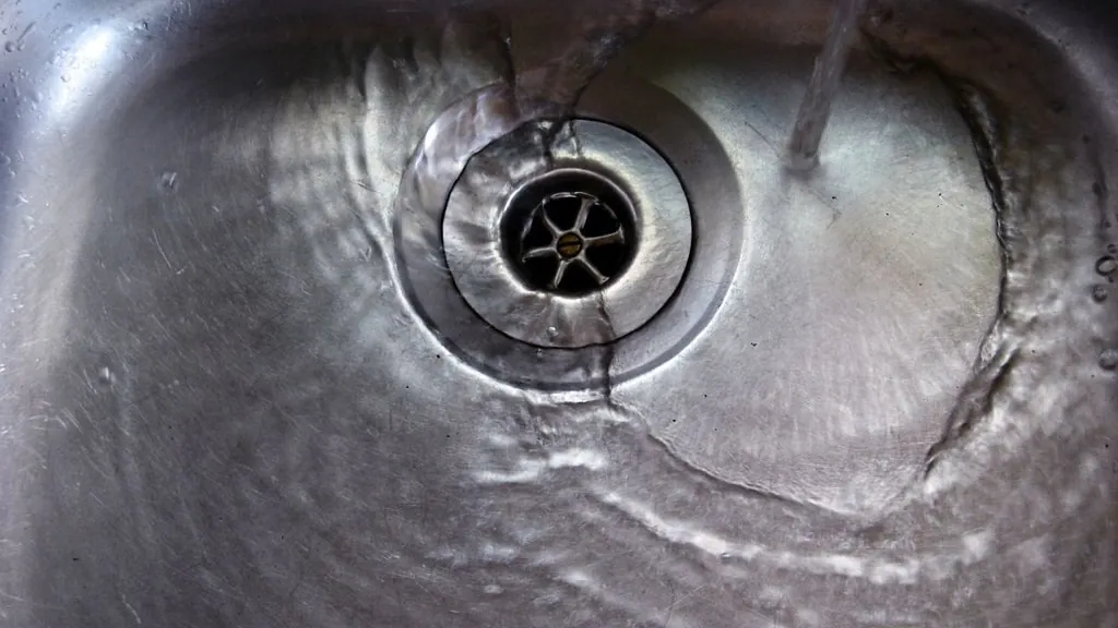 Water running into a stainless steel sink drain