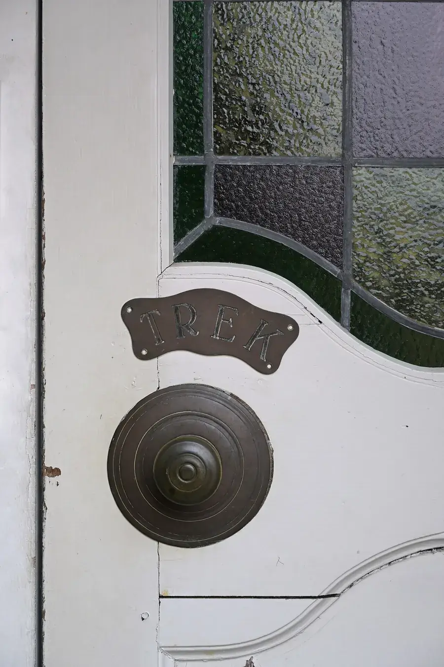 Round door knob and latch plate on a white door