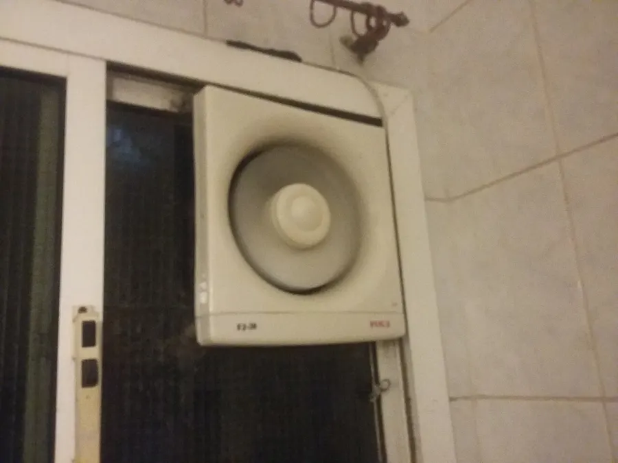 Wall exhaust fan mounted in a tiled bathroom