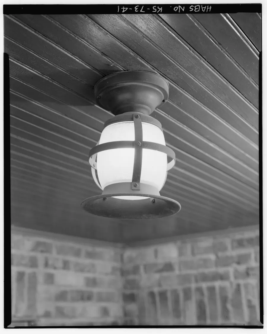 Enclosed porch ceiling light under a wood-slat porch roof