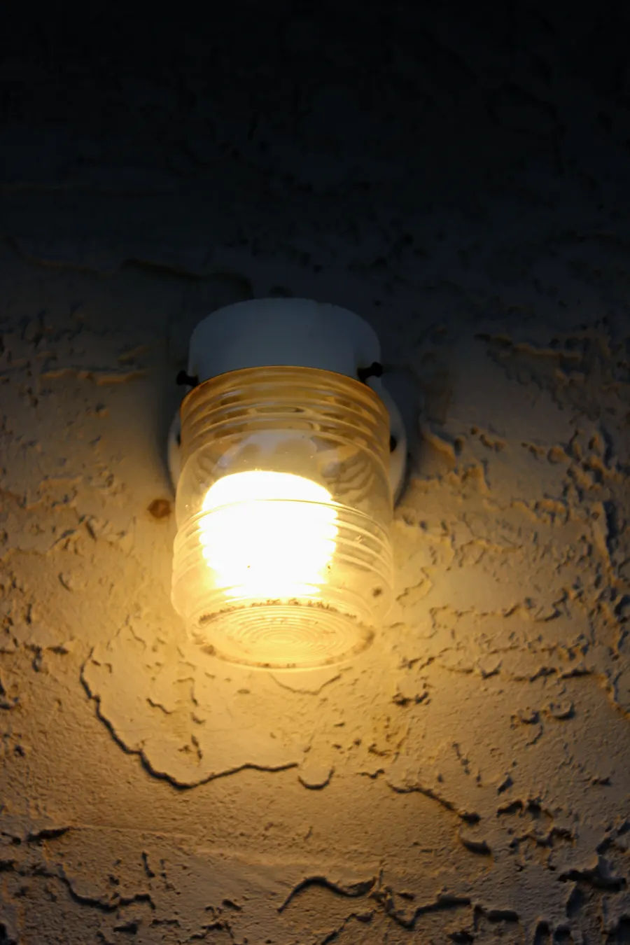 Porch light with a glass globe on a textured exterior wall