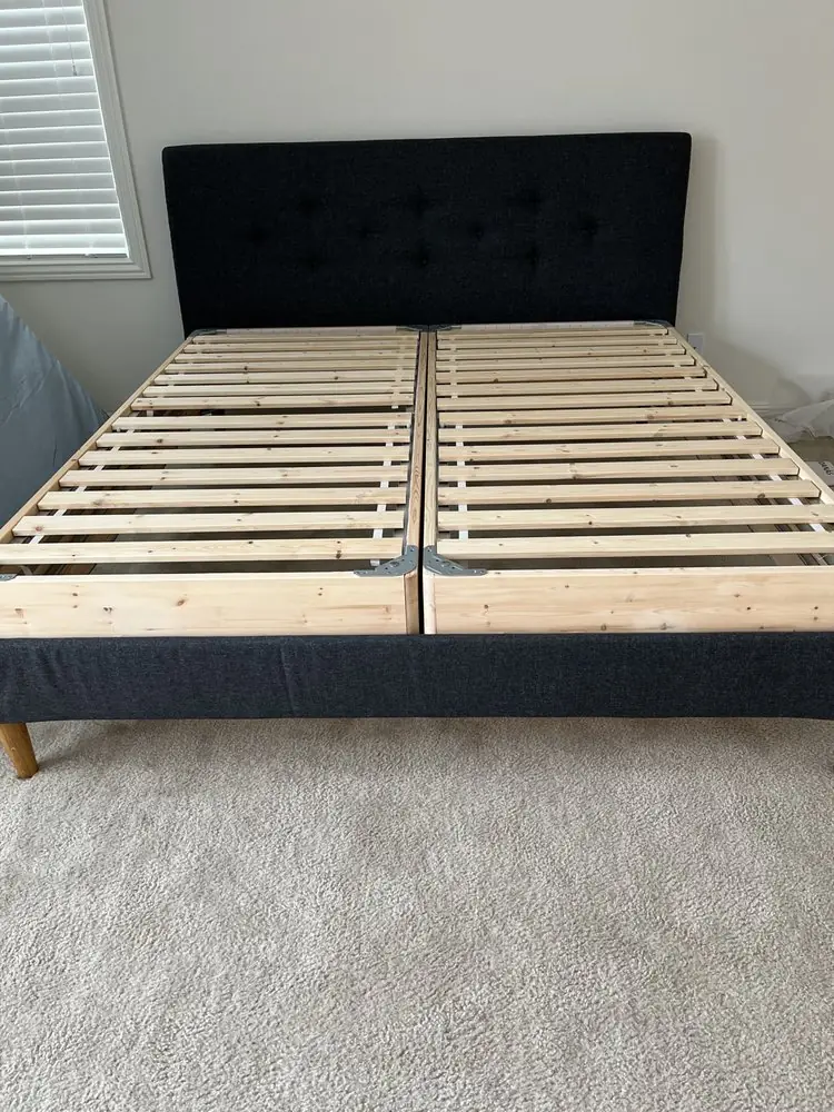 Platform bed frame assembled on a carpeted floor