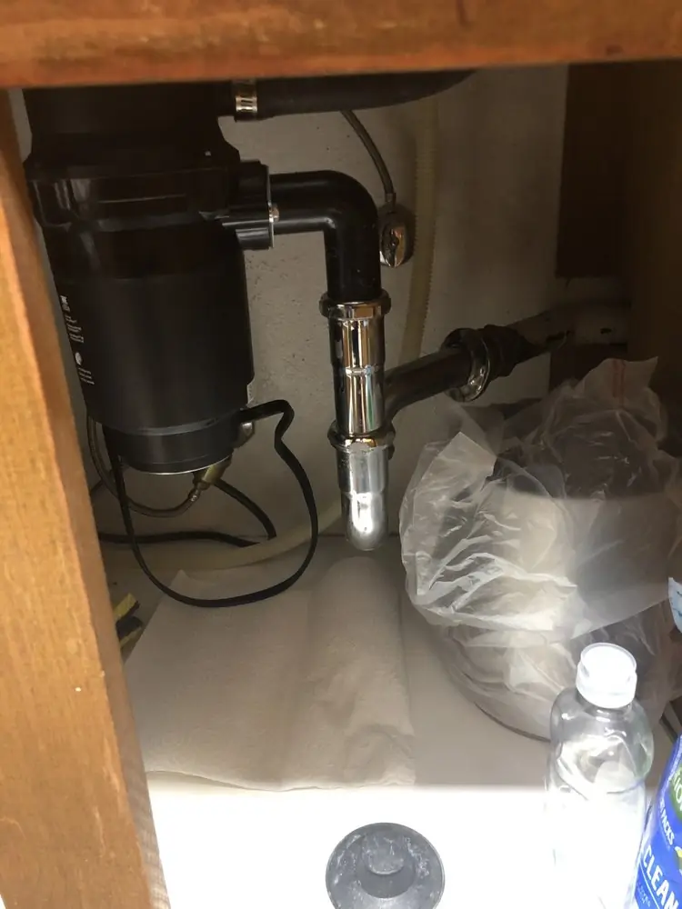 Garbage disposal and drain line inside a sink cabinet