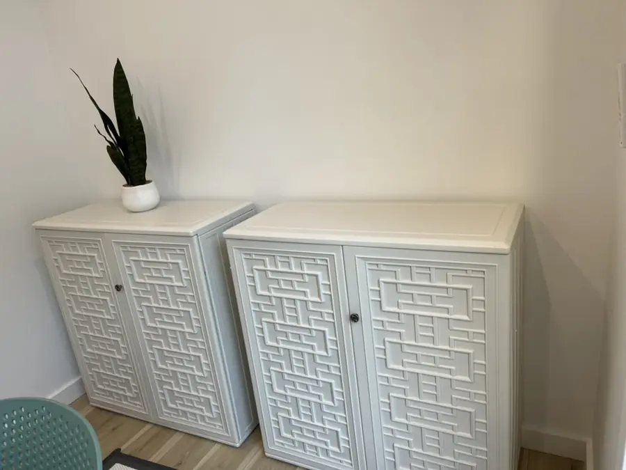 Pair of white lattice-front cabinets assembled and leveled