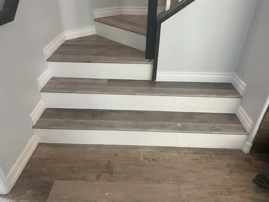Stair landing with new treads and white baseboard trim