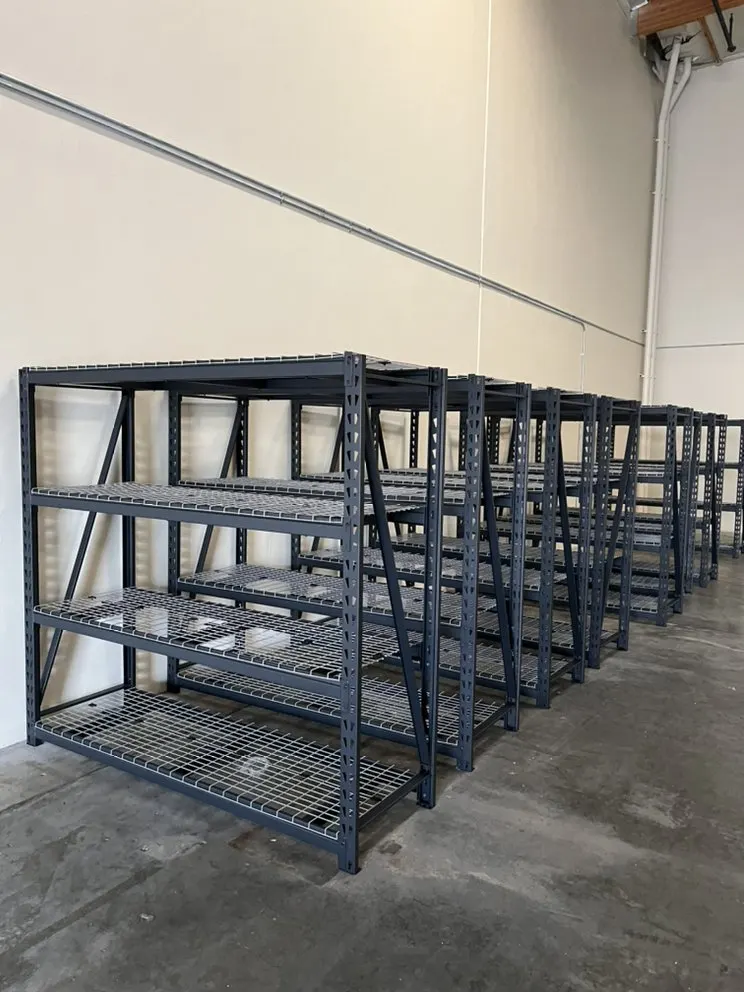 Row of heavy-duty metal shelving units assembled along a wall