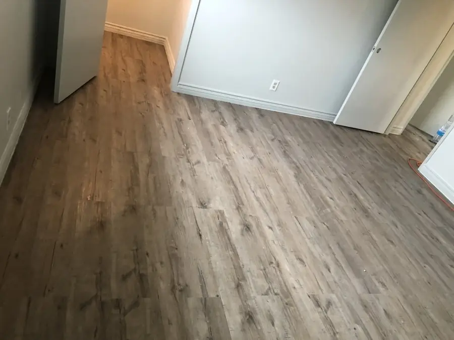 Empty rental room with new plank flooring ready for move-in