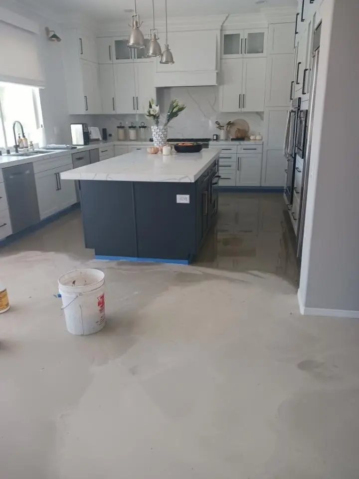 Kitchen with white cabinets and an island after new flooring went down