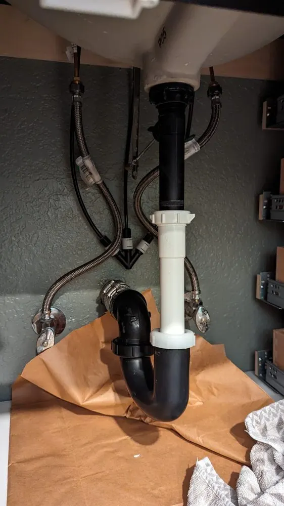 New P-trap and tailpiece installed under a sink